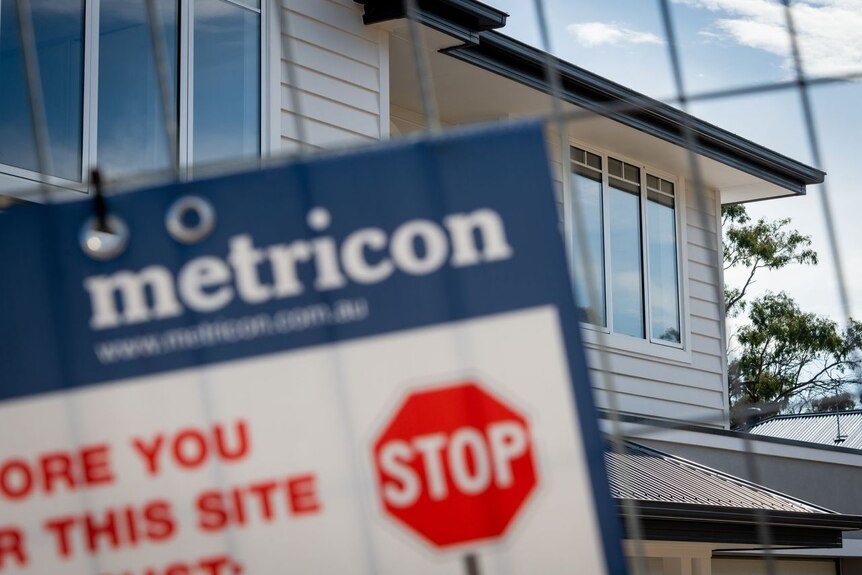 A metricon sign blurred over a home