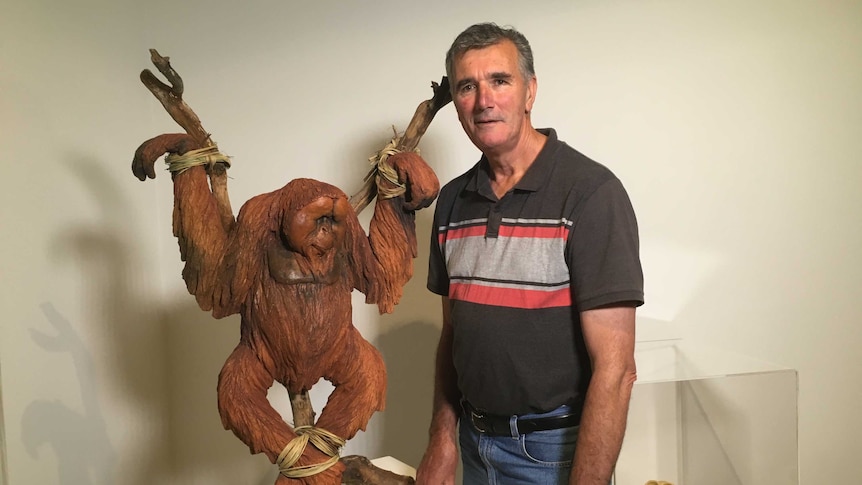 Chris Stubbs with the clay sculpture, which depicts a crucified orangutan.