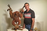 Chris Stubbs with the clay sculpture, which depicts a crucified orangutan.