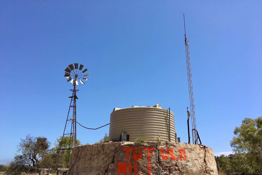 A windmill, tank and signal tower on a remote property in WA
