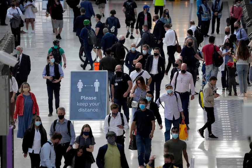 People wear face masks during the morning rush hour at Waterloo train station in London
