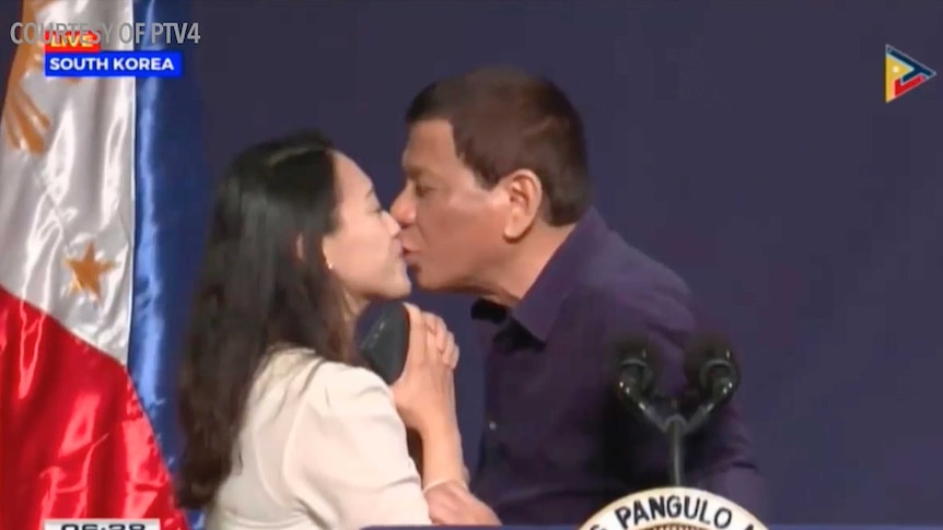 Philippines President Rodrigo Duterte kisses a woman.