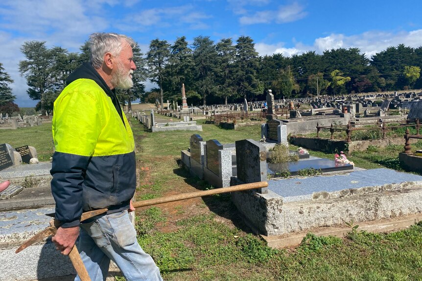 man walking through a cemetery.