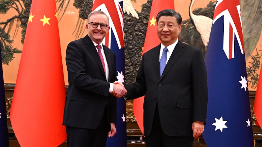 Anthony Albanese shakes hands with Xi Jinping in front of the Australian and Chiense flags in Beijing.