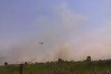 A helicopter flies over a bushfire burning in Cabarita