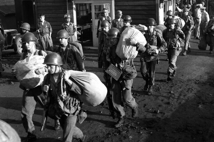 American foot soldiers leave the railroad station at Taejon, South Korea, in 1950.