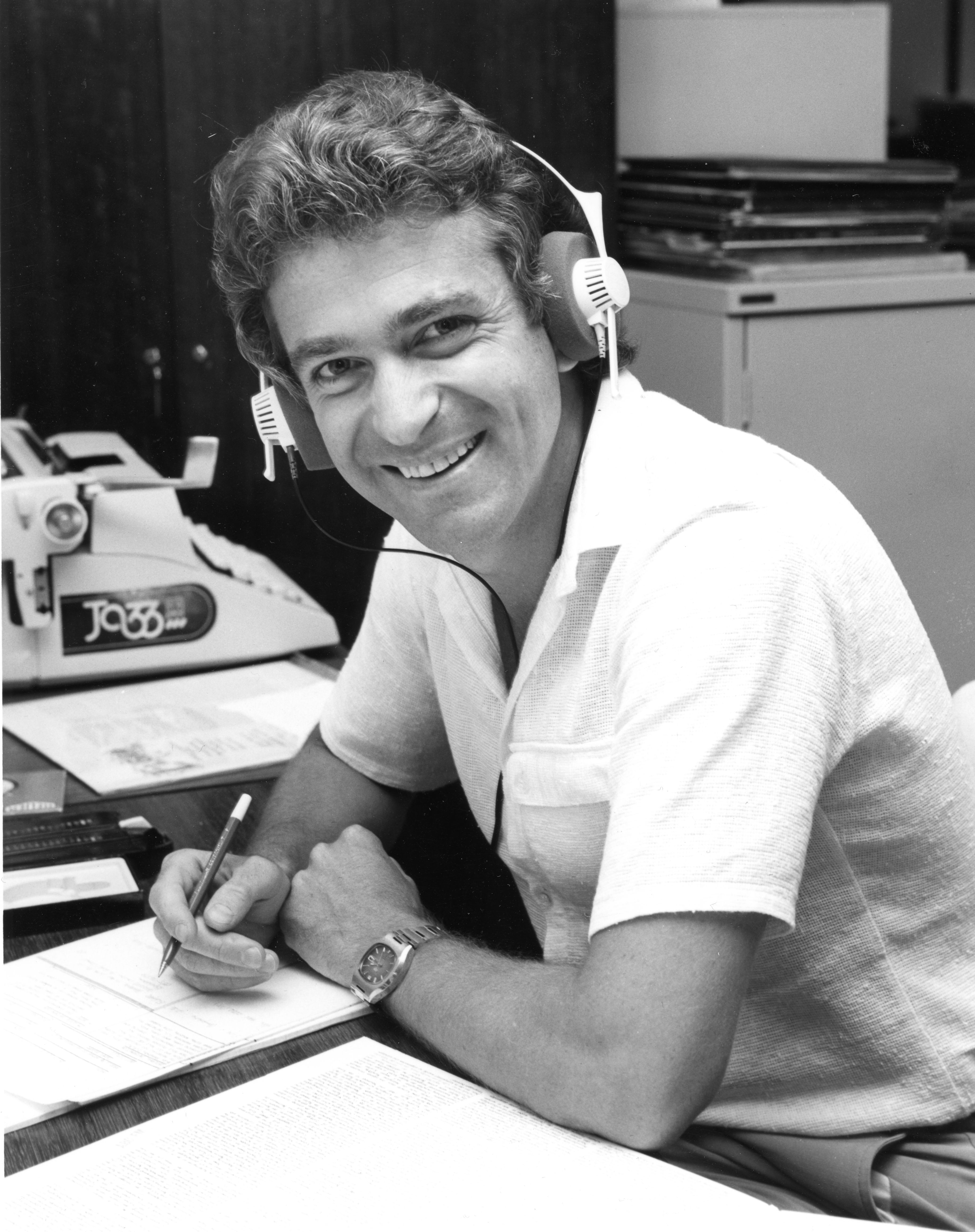 Stephen Watkins wearing headphones and smiling at the camera.