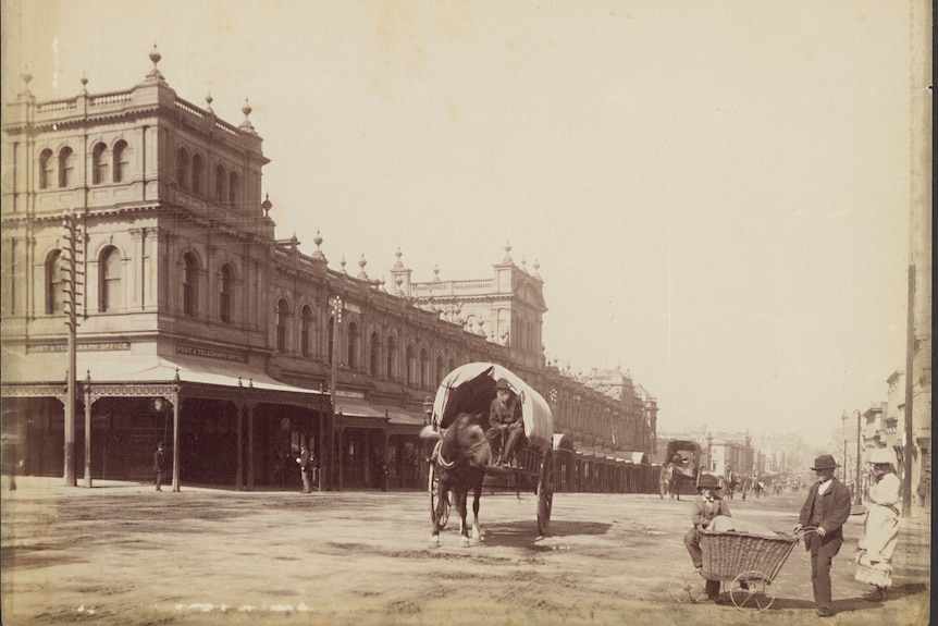 A brown and white very old photograph showing a horse and cart and a market building in Melbourne.
