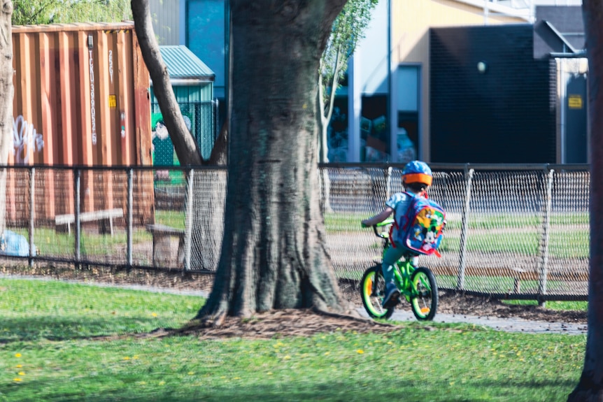 A child cycles along a footpath.