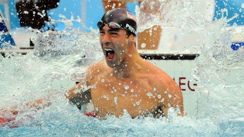 One to go: Michael Phelps celebrates his narrow win in the 100m butterfly final.