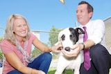 Mark McGowan and wife Sarah, crouching down with dog "Oprah"