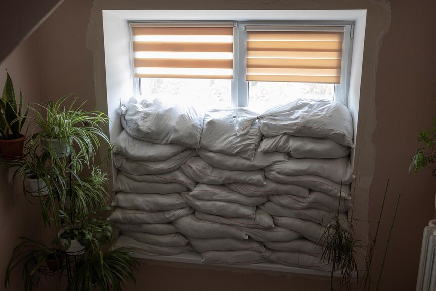 Sandbags are piled against the inside of a window in a hospital. 