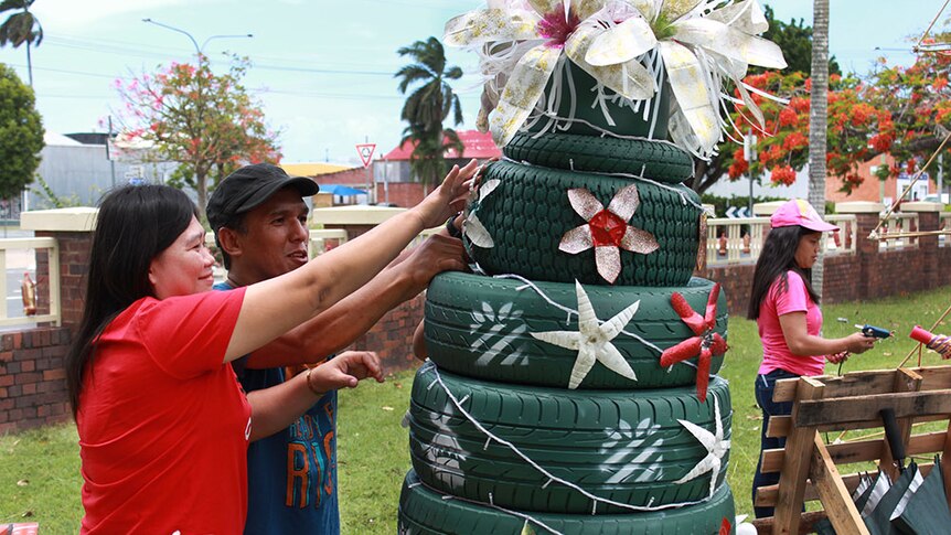 Volunteers working on a Christmas tree made out of tyres,