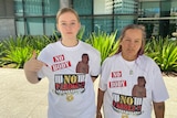 Nikita Buhse and Caroline Jones wearing shirts that say 'no body, no parole' on them. Nikita is pointing at the message.
