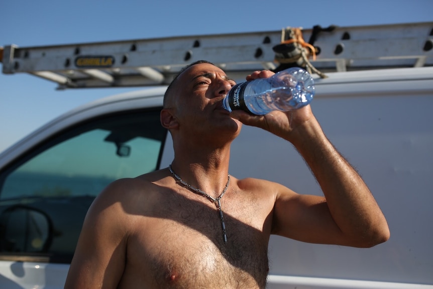 man drinking water in the heat