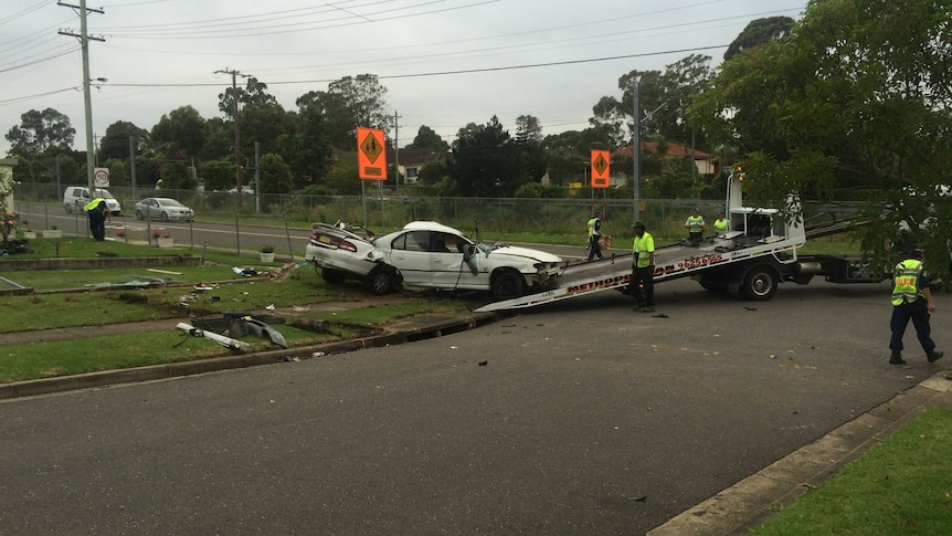 Car being removed from crash site after it rolled off the road in Sydney.