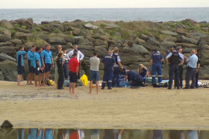 Emergency services gathered on beach.