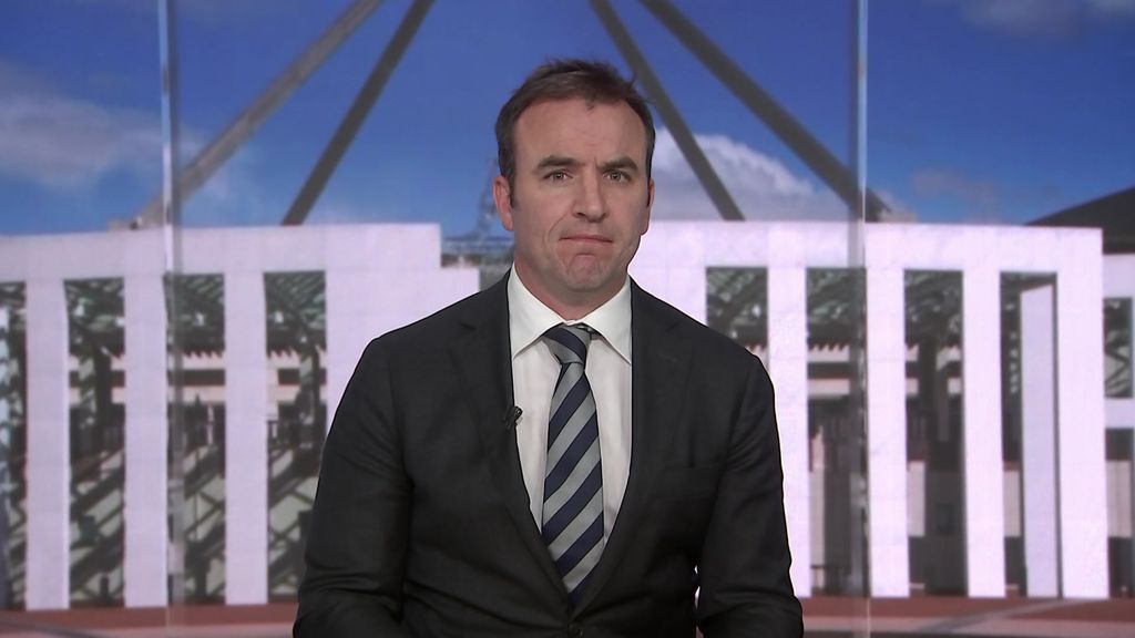 A man in a suit and tie in front of a greenscreen of the Parliament House.