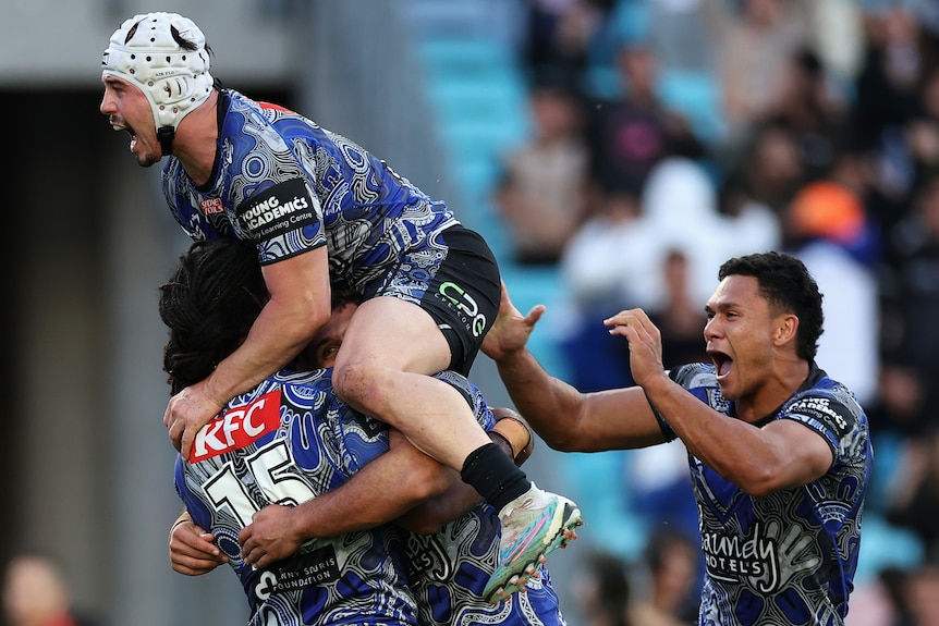Four Canterbury NRL players celebrate a try against Gold Coast.