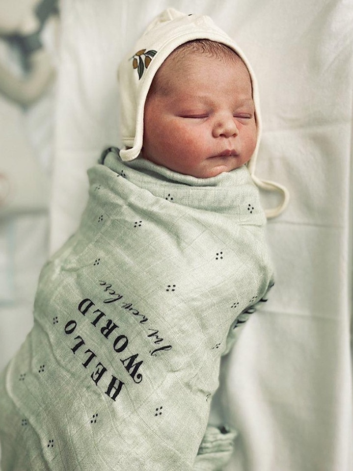 Newborn baby in blanket and cap