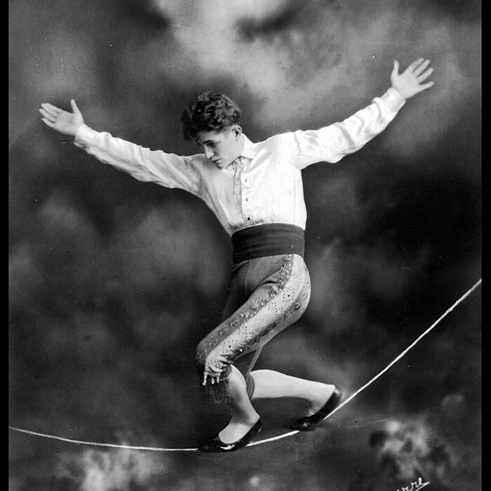 Black and white photograph from the 1920s of Con Colleano walking on a slack wire, in a circus act.