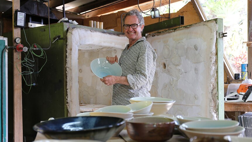 Suvira McDonald stands next to kiln