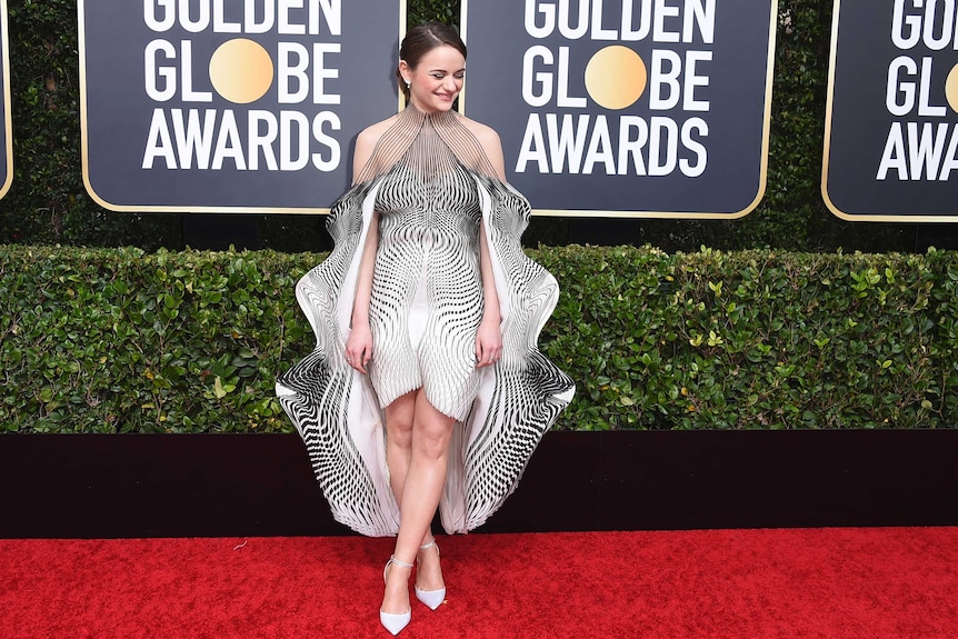 Actress Joey King arrives on the Golden Globes red carpet in an optical illusion-inspired half-length dress.