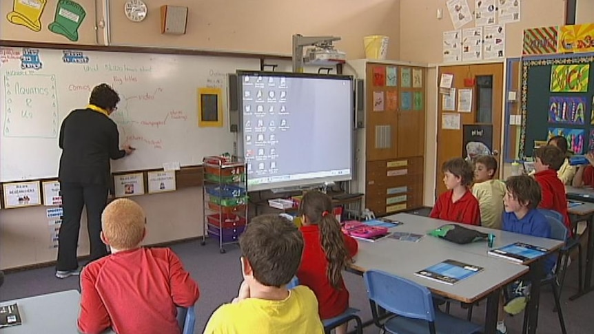 A teacher in front of the classroom teaching children.