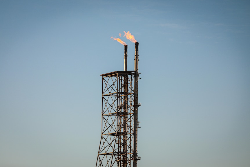 A flare tower with two flames at the top.