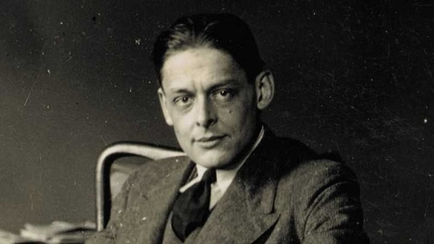 Black and white photo of a seated middle aged white man wearing a suit