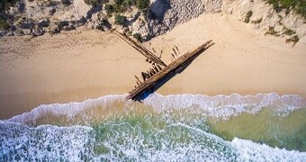 Aerial shot of shipwreck on the sand.