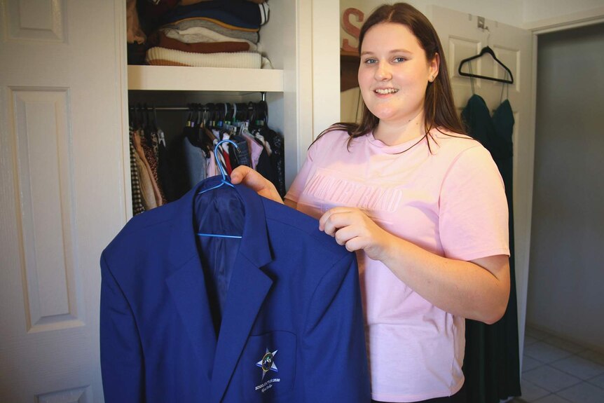 A teenager holding a school blazer