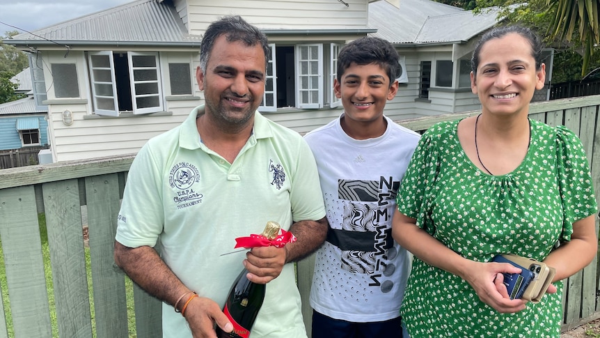 Family of 3 outside their new home