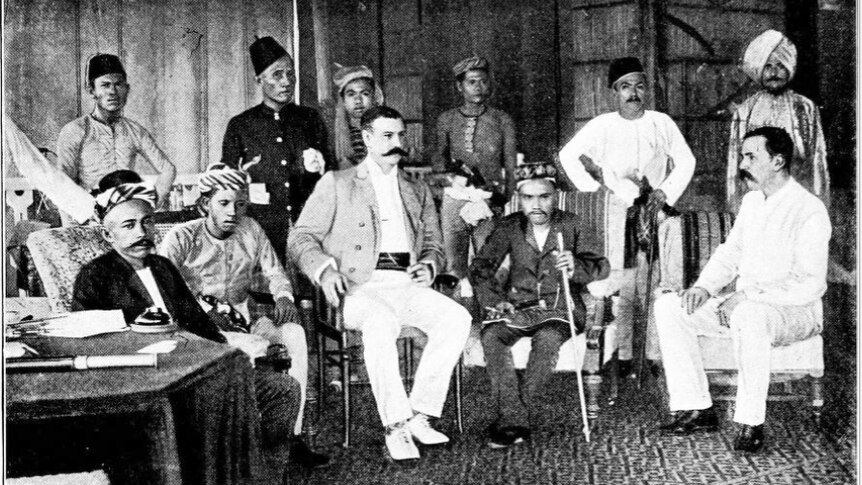 A black and white photo taken in 1899 of members of the BNBC sitting with the then Sultan of Sulu and his entourage.