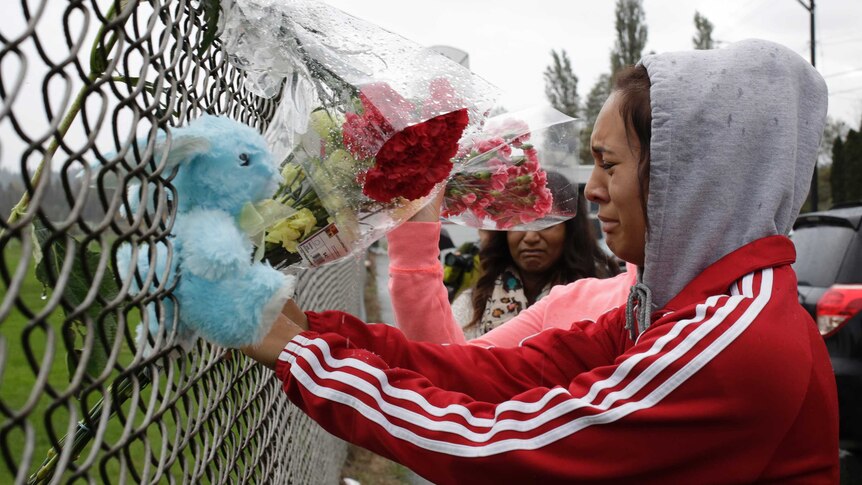 Student places flowers following Marysville school shooting