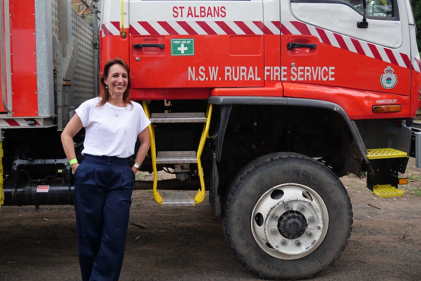 RFS St Albans captain Lilly Stepanovich stands in front of a firefighting truck.