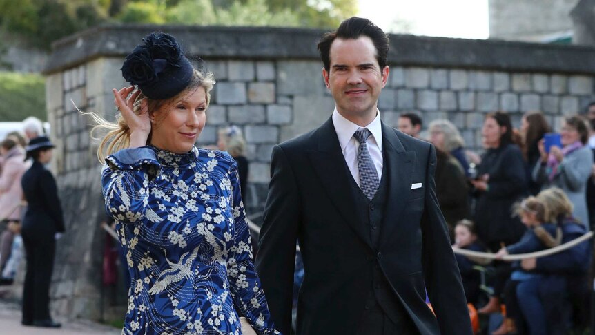 Jimmy Carr and Karoline Copping, who wears a blue flowery dress holding her hat