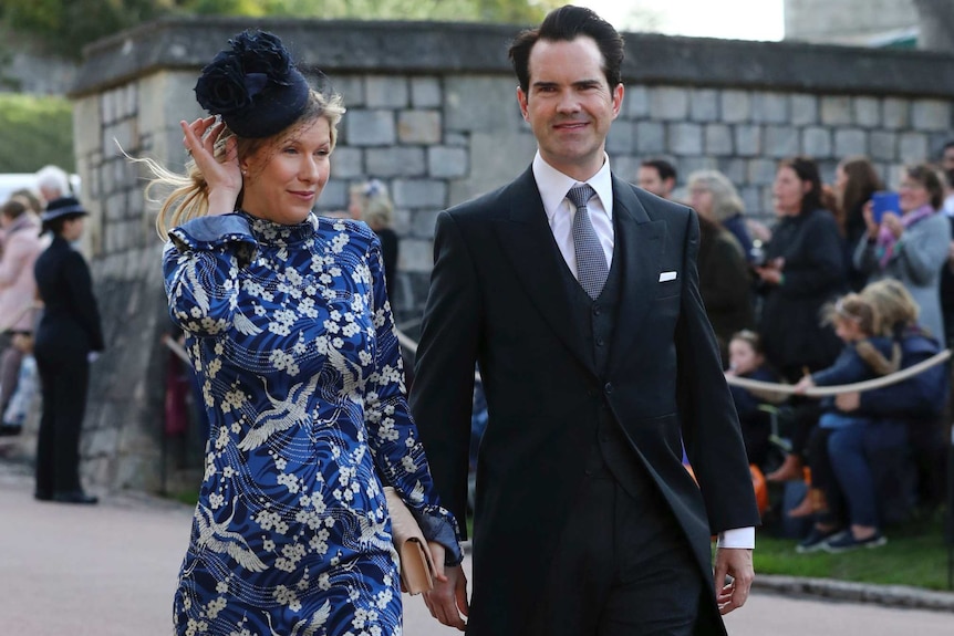 Jimmy Carr and Karoline Copping, who wears a blue flowery dress holding her hat