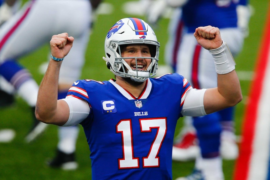 Josh Allen celebrates with a smile on his face and clenching both his fists either side of his head
