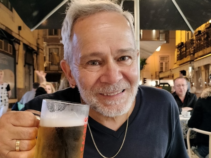 A photo of an older man drinking a beer