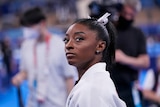 Simone Biles looks off to one side