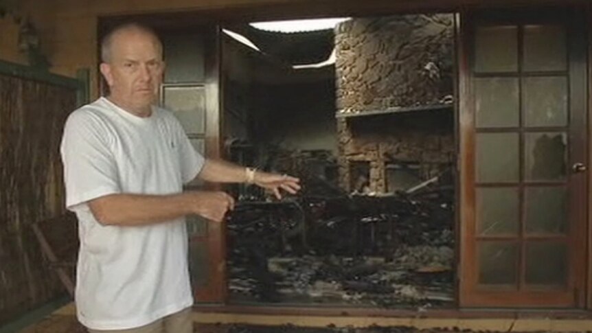 Richard Camm points to the destruction caused by a fire at his Yallingup home