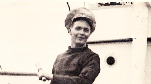 Donald Garnham on the deck of a ship.