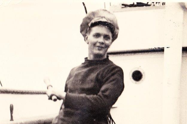 Donald Garnham on the deck of a ship.