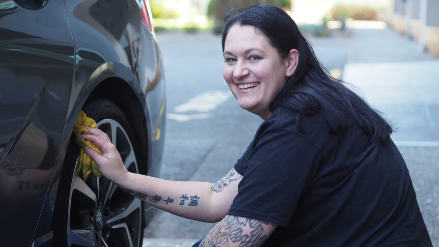 Cara Bertoli cleans the wheel of her new Holden Commodore