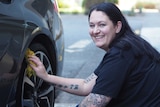 Cara Bertoli cleans the wheel of her new Holden Commodore