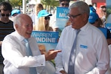 Former PM John Howard smiles and points at the Liberal Party's Gilmore candidate, Warren Mundine.