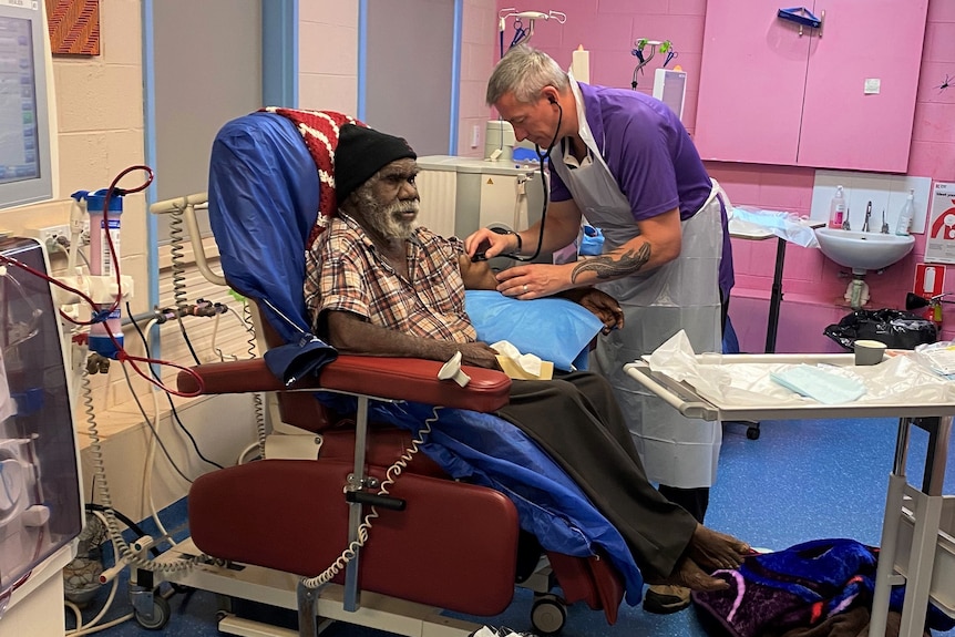 An older man treating another man at a dialysis clinic