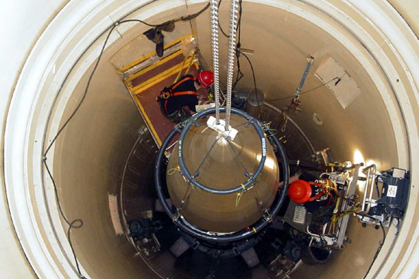 US Air Force maintenance team removes upper section of an intercontinental ballistic missile.