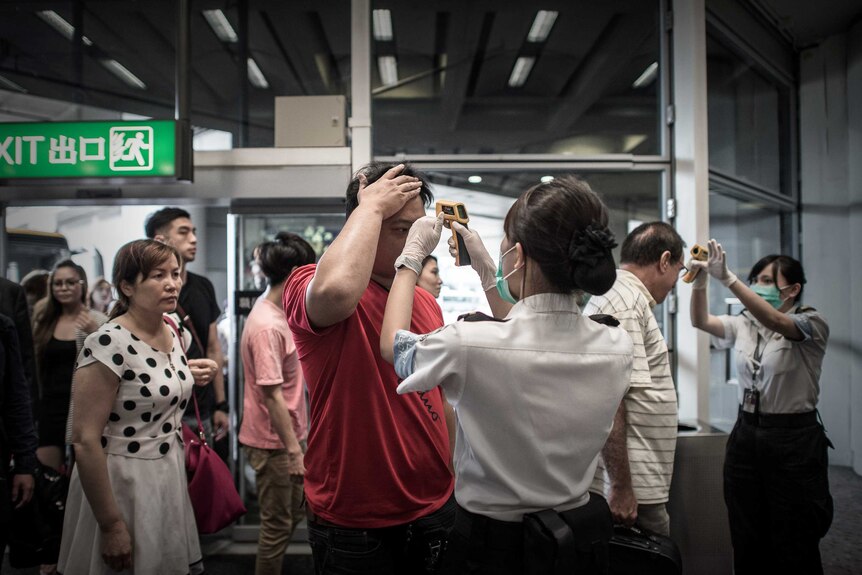 Passengers in Hong Kong have their temperature checked